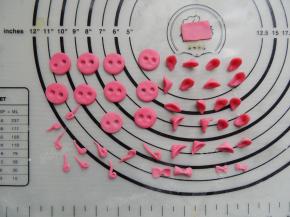 剩下的红色面团可以搓成细细的卷曲的猪尾巴，还可以做成小蝴蝶结、小玫瑰花等装饰。