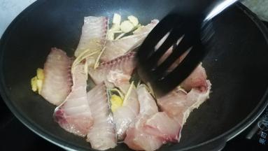 用锅铲铺平鱼块