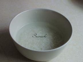 大米洗净放入大盘子里，倒入适量的饮用水浸泡一个晚上。