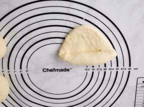 用擀杖擀成椭圆形。然后将椭圆形的面团从上到下卷起来。