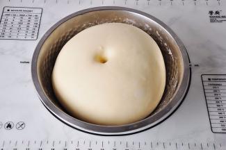 揉好的面团放在盆中，盖上保鲜膜进行发酵。天冷如果您家的室温底，也可以直接将面团放在面包机中发酵，等面团发酵至原来的2.5~3倍大即可。