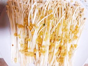 把爆香的蒜末淋入金针菇上。