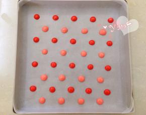 28*28烤盘铺油布，裱花袋剪小口，将两种颜色的面糊分别挤出波点。放入烤箱，165度烤4分钟。