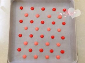 28*28烤盘铺油布，裱花袋剪小口，将两种颜色的面糊分别挤出波点。放入烤箱，165度烤4分钟。