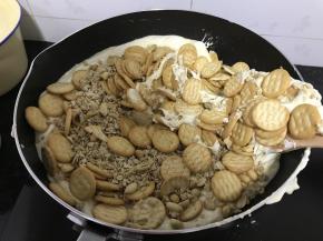 饼干提前掰碎 趁热把燕麦和花生仁倒入锅中， 用一次性手套抓匀（燕麦片可以换成蔓越莓，坚果等）