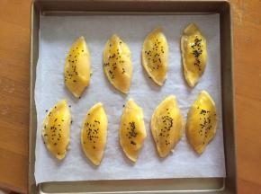 烤了10分钟后拿出，去掉蛋挞盒，注意烫手，刷上蛋黄液，撒上黑芝麻，放入烤箱继续烤15分钟