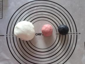 分两个适量的糯米团，加入红丝绒粉和竹炭粉揉均匀