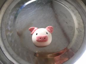 再用红丝绒糯米团做成耳朵和鼻子，沾一点水，粘在揉好的汤圆上面，用牙签在鼻子上戳两个洞，可以戳大一点，眼睛用黑芝麻装饰