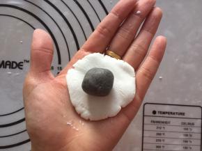 白色糯米团15克，压扁，包入黑芝麻馅