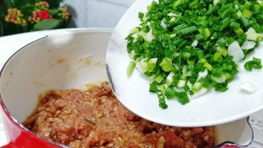 用筷子顺着一个方向搅打上劲加入葱花。