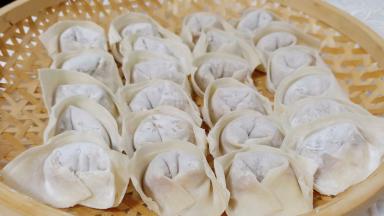 取一张馄饨皮，加上肉馅包起来即可。