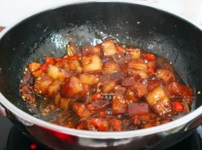 倒入焖好的五花肉捞出倒入锅里、加点麻油翻炒，接着把焖五花肉的油脂也倒入锅里，翻炒，变炒变收汁，让五花肉和辣椒完美结合，