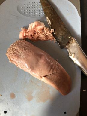 用刀或者指甲把猪舌的白色舌苔刮去。