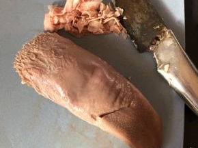 用刀或者指甲把猪舌的白色舌苔刮去。