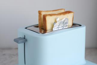将两片吐司片（包括盖着佩琪的吐司片）一起放入多士炉里。