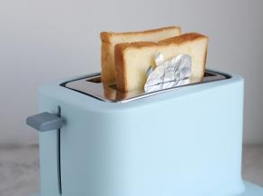 将两片吐司片（包括盖着佩琪的吐司片）一起放入多士炉里。