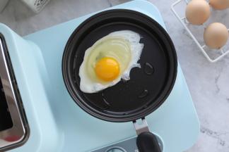 火候按钮旋转至大火，磕入鸡蛋。