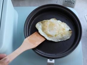 用早餐机配套的木铲翻面，煎至鸡蛋两面金黄色。