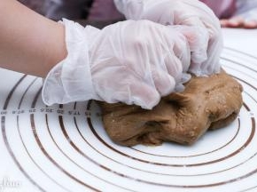 用刮刀倒在揉面垫上，乘温热速揉匀。