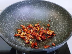 另起油锅，加入切好的腊肠煸炒。