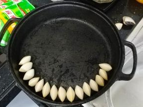 将白贝再清洗一次沥干水分，在浅锅边齐正排好，如图