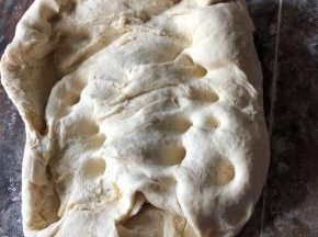 把发酵好的面团取出，用手揉搓，给面团排气，面团比较大，可以分批揉面，揉好的面盖上保鲜膜松弛15分钟就可以了。