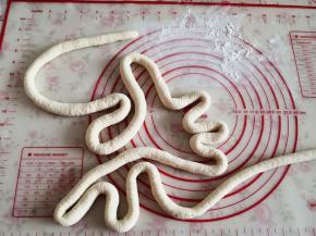 4.	将面团拿出来反复揉搓成光滑的面团，然后取一块将其揉搓成细长条，粗细如手指头一般，