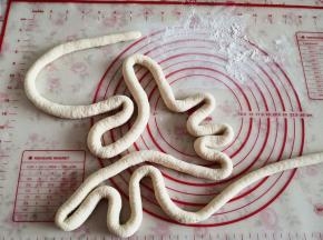 4.	将面团拿出来反复揉搓成光滑的面团，然后取一块将其揉搓成细长条，粗细如手指头一般，