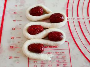 11.	再取一块面团揉搓成更细一些的长条，摆成回形状，转弯处放上大枣，