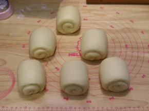 再次将面团擀成牛舌状，从上往下卷好。