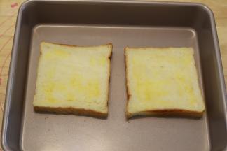 放入烤盘，黄油融化后刷在吐司片上。