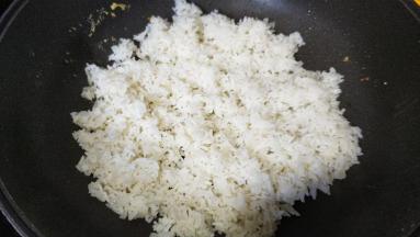 锅里热油，倒入剩米饭、蒜盐炒均匀