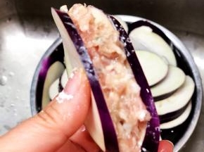 在茄子里面抹上少许生粉，把肉馅酿在夹缝里。