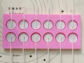 然后把棒棒糖糯米纸正面向下放在糖浆上，再把纸棒放上。