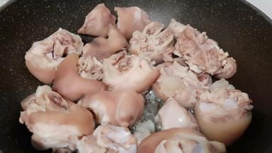 锅里倒油、油温五成热下猪蹄煎一下。