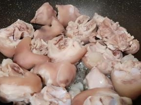 锅里倒油、油温五成热下猪蹄煎一下。