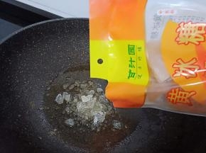煎好的猪蹄盛盘，留下的底油加入冰糖30克开小火慢慢化开。