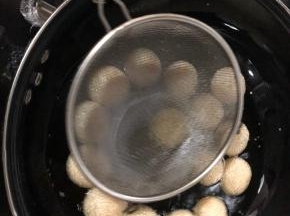 等油温差不多六成热，麻团浮起来以后用一个漏网勺不停的滚动团子，并轻轻按压团子，等团子鼓起来再按压，多按压几次，据说这是团子长大空心的关键。