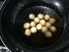 油三成热后放入芝麻小团子。用最小火加热，强调一下炸麻团油温一定不能高，所以全程用最小火即可！