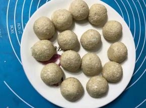 搓圆的团子沾点水滚上芝麻，滚好芝麻后可以再用手搓一搓，让它更圆。(沾水是为了让芝麻不掉落。)