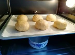 烤箱调至“发酵”功能，放入一碗热水，将面包生胚送入烤箱二次发酵。