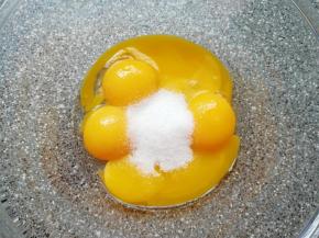 给蛋黄里面加入15g细砂糖，用手动打蛋器搅打均匀。