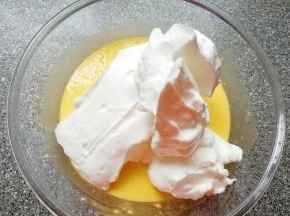 打发好的蛋白取三分之一加入到蛋黄糊里面，用硅胶刮刀采用切拌和翻拌的方法混合均匀。