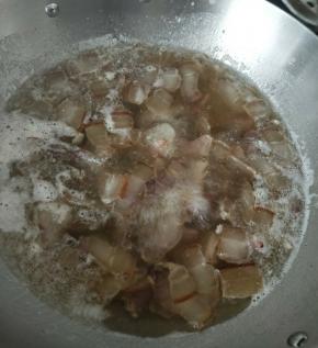冷水中放入腊肉和姜片，煮一两分钟后捞出。