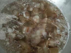 冷水中放入腊肉和姜片，煮一两分钟后捞出。