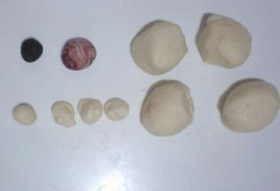 把面团分出:1个2克与奥利奥饼干碎沫混合揉搓均匀(金鱼眼睛)，太干可加适量清水。
1个5克与红曲米粉混合揉搓成团，不均匀更好噢，均匀也可。
4个1.5克的小面团(金鱼眼睛面团)。
4个32克左右的大面团用来制作金鱼主体。(因面粉干湿度不同，用水量不同，所以把剩余分成4等份即可，不一定是32克噢)