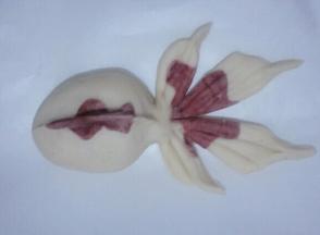 把尾巴从中间向两边切三刀如图