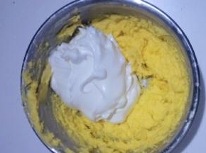 取二分之一蛋白加入黄油糊中翻拌均匀，不可画圈搅拌