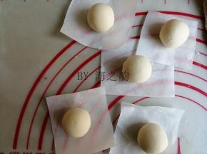 面团分出5个10克的小面团，揉圆后放在油纸上。12克面团加入草莓粉揉成粉色面团，17克面团加入红曲粉揉成红色面团，10克面团加入南瓜粉揉成黄色面团，2克面团加入竹炭粉揉成黑色面团