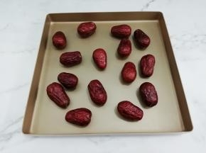 擦干水的大枣放在烤盘上，然后放入烤箱，中层100度烤十分钟